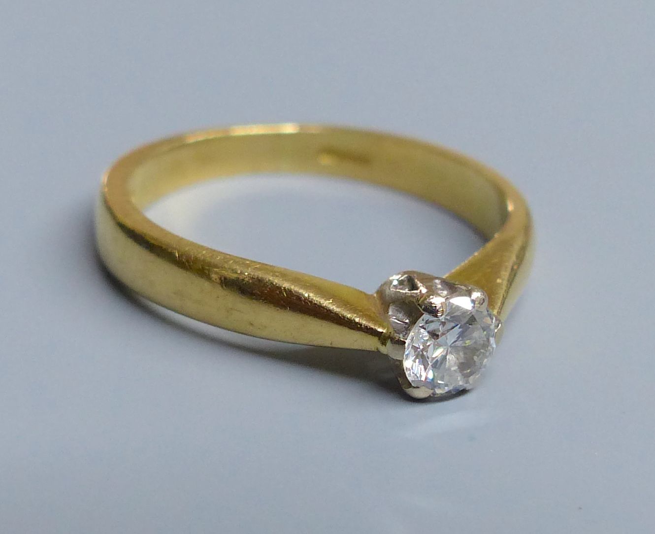 A modern 18ct gold and solitaire diamond ring, size H/I, gross 3 grams.